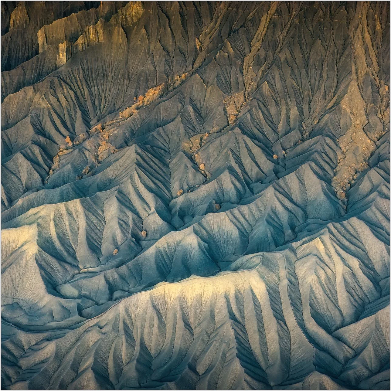 Aerial view of eroded badlands textures and branching patterns in Utah desert