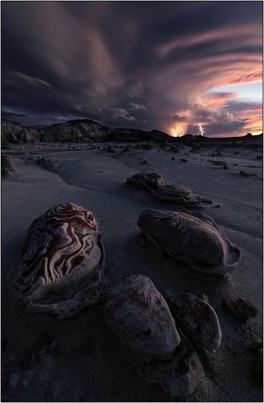 Badlands landscape under a thunderstorm with lightning strikes