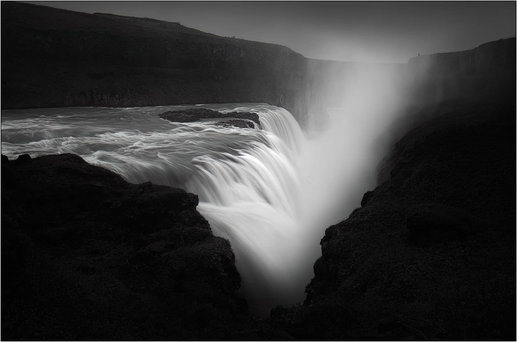 Black and white moody image of Gullfoss, Iceland, with long exposure water flow and mist.
