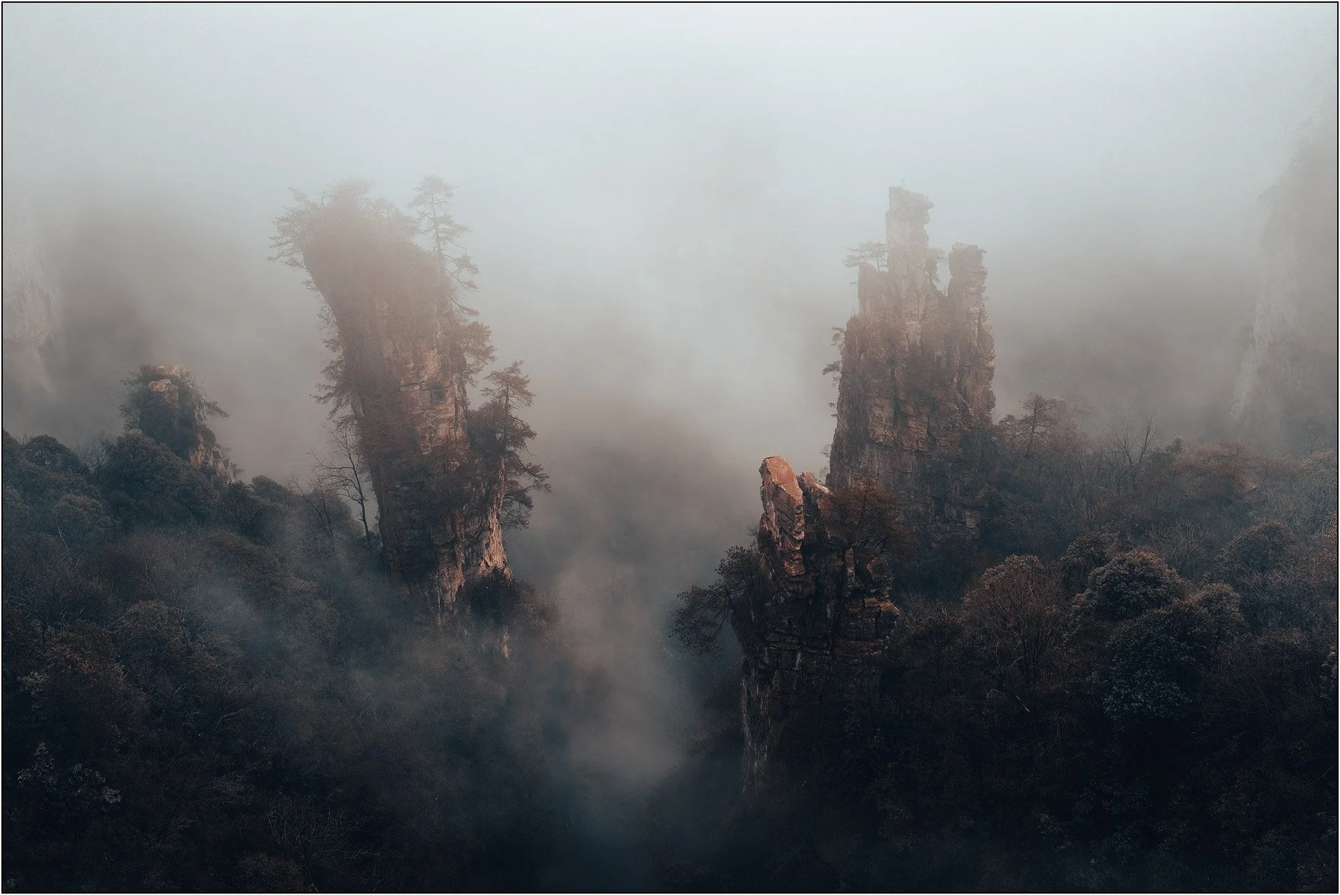 Sandstone mountains emerging through drifting mist and clouds in Zhangjiajie, China.