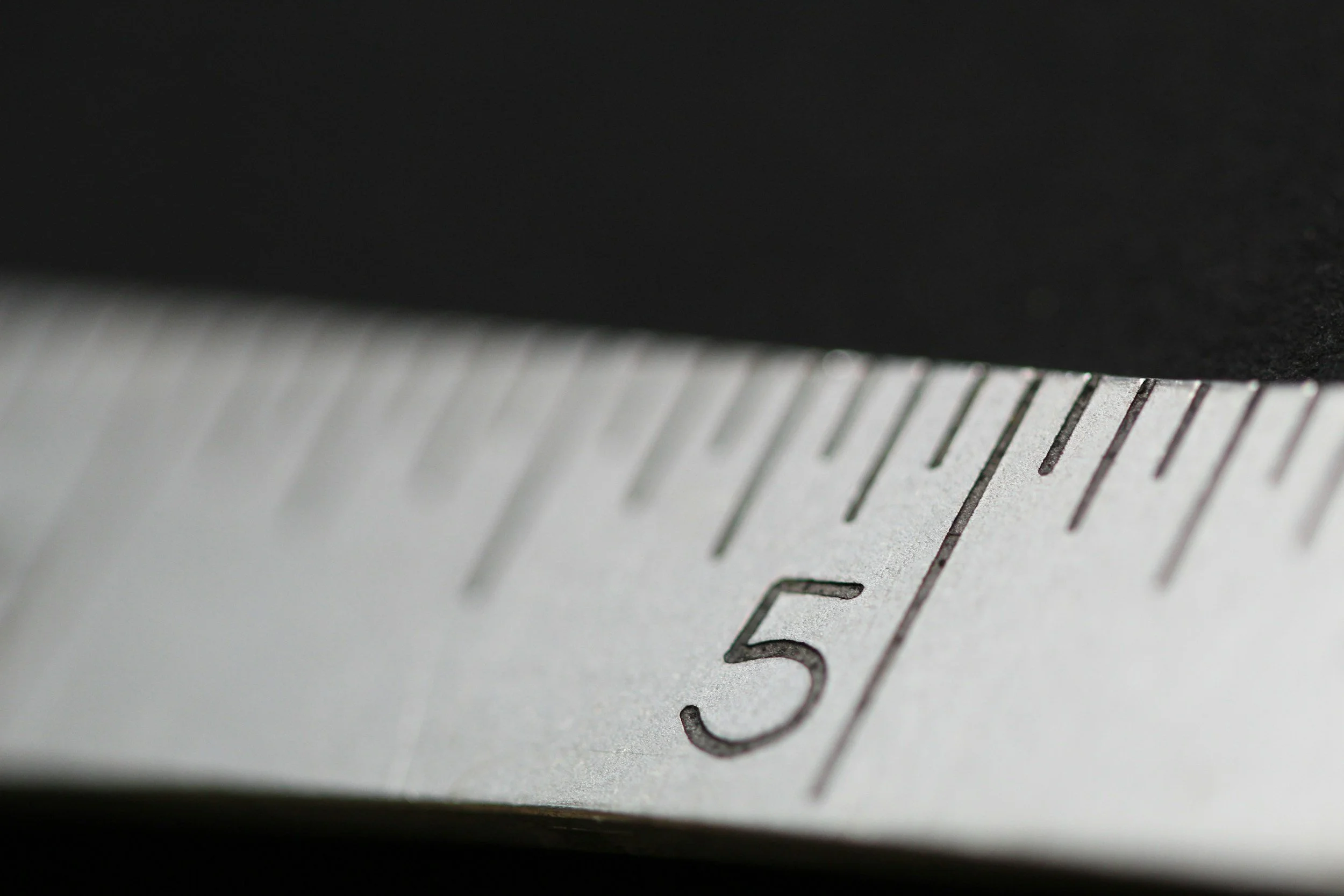 Close-up of a metal ruler with measurement markings, focusing on the number 3.