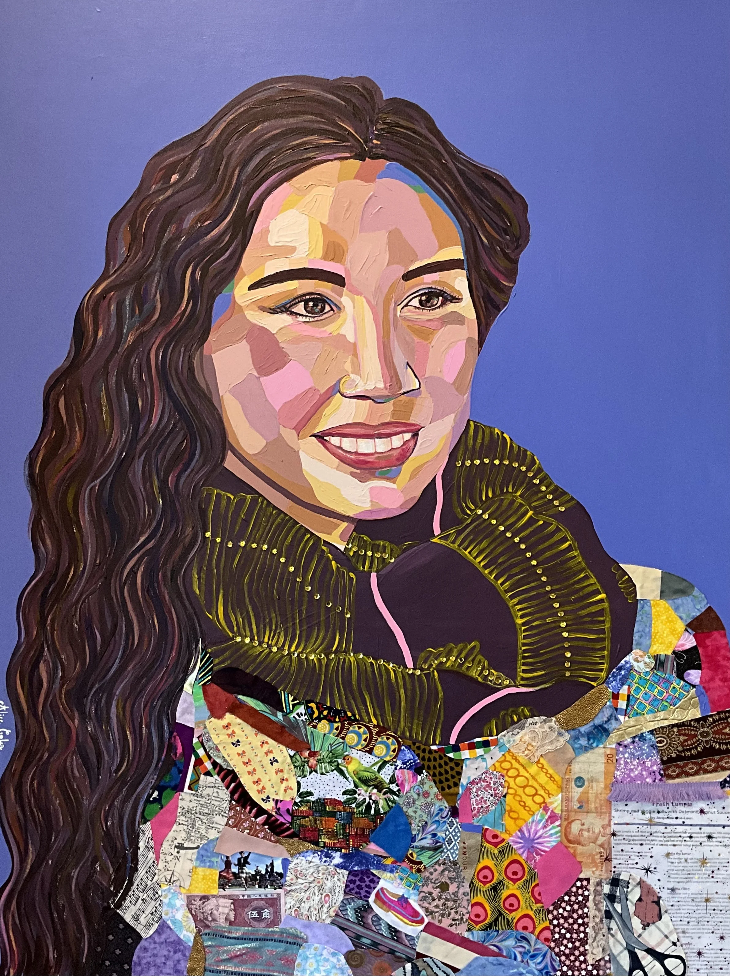 Colorful collage portrait of a woman with long, wavy hair and a bright smile, made from various pieces of patterned paper and fabric on a blue background.