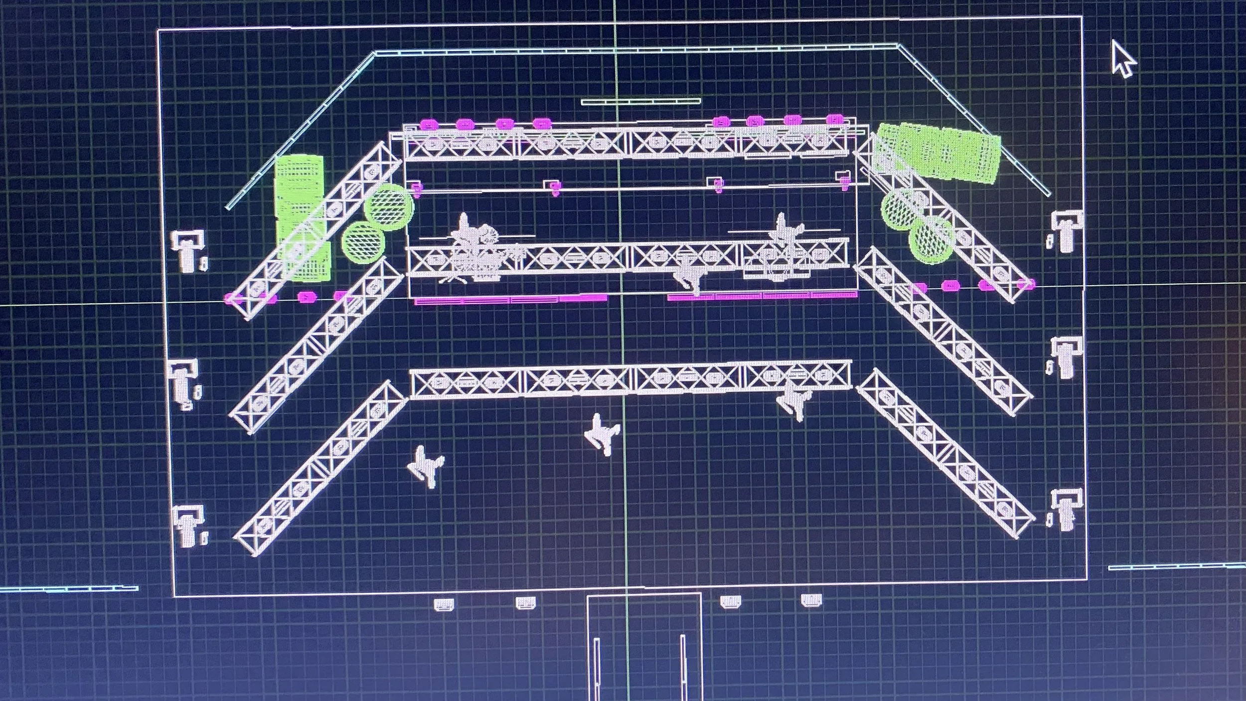 Blueprint of a stage or event setup with trusses, speakers, and aircraft icons on a digital grid background.