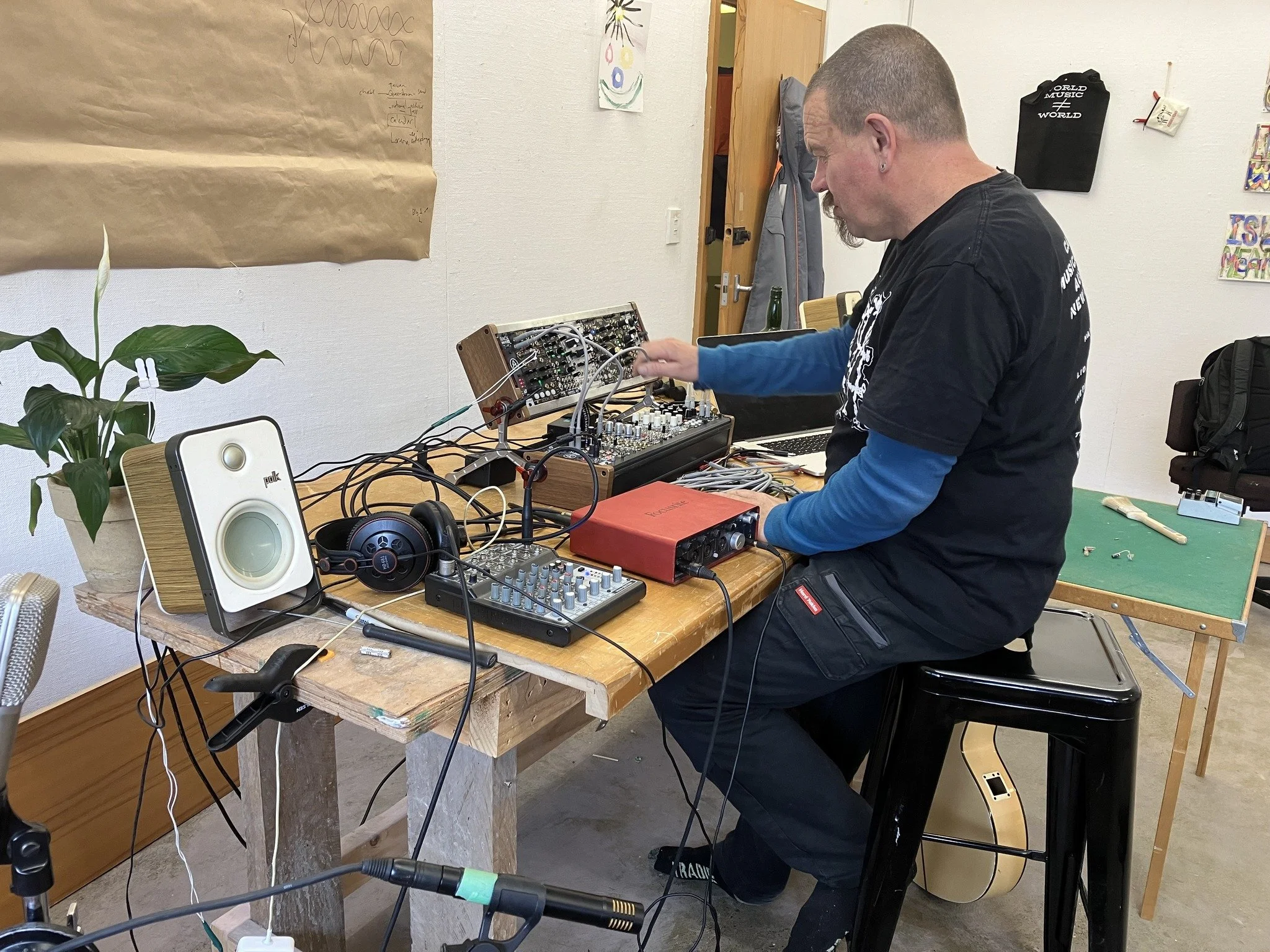 Musical artist experimenting with audio equipment