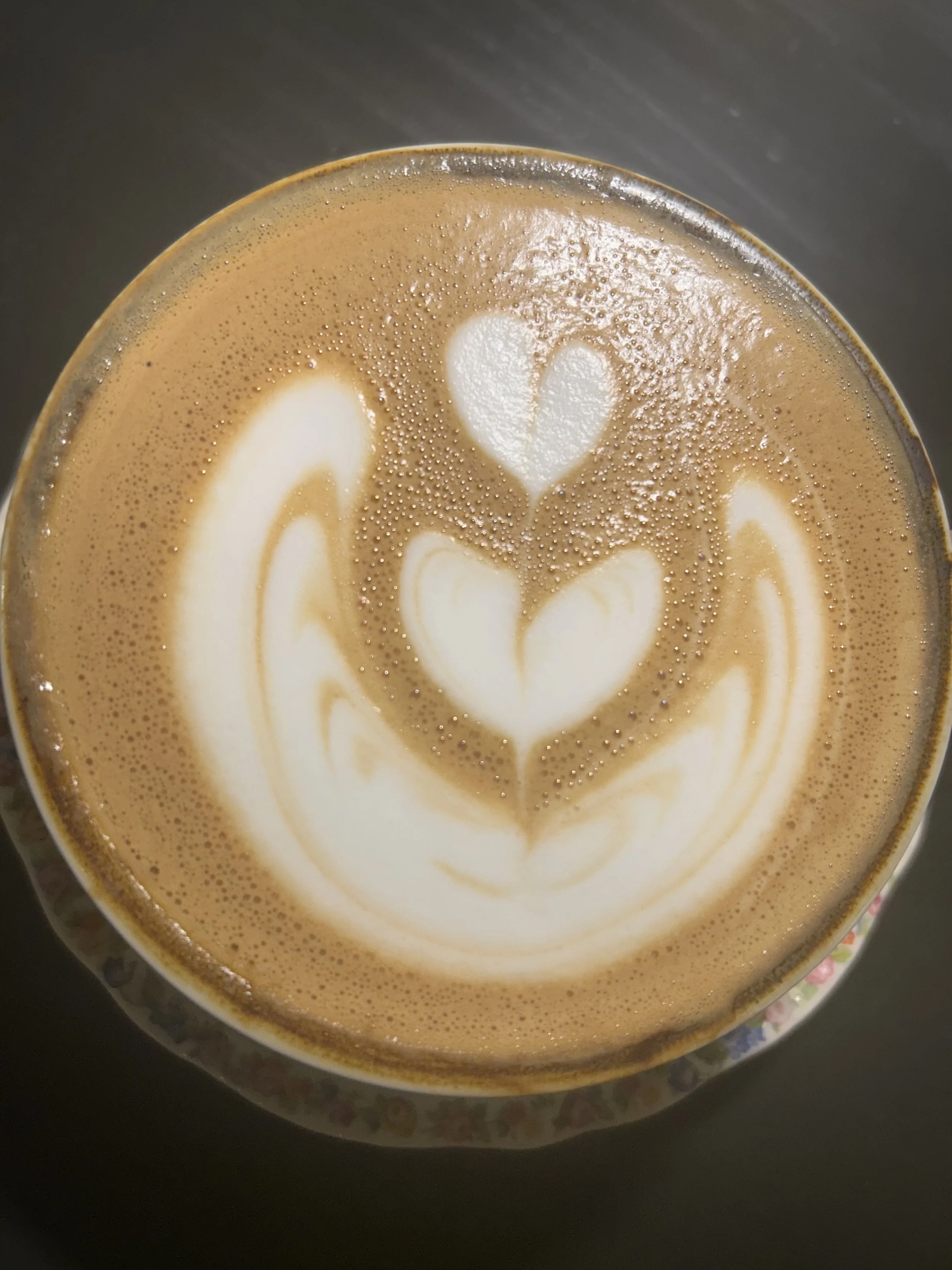 A cup of coffee with latte art hearts on top. Vintage Coffeehouse