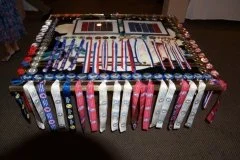 Table covered with various colorful ribbons, medals, and awards arranged neatly.