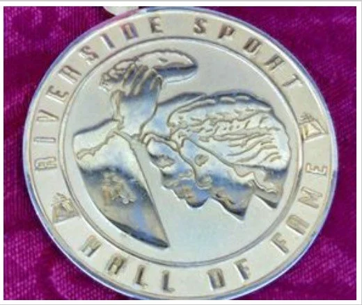 A silver coin with a man's profile image, with the text 'REVEAL THE SPART' at the top and 'HALL OF FAME' at the bottom.
