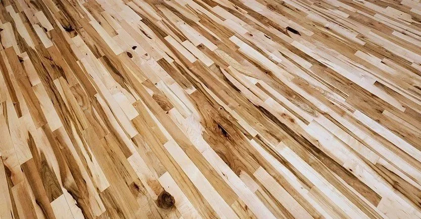 Close-up of a wooden floor with a curved striping pattern