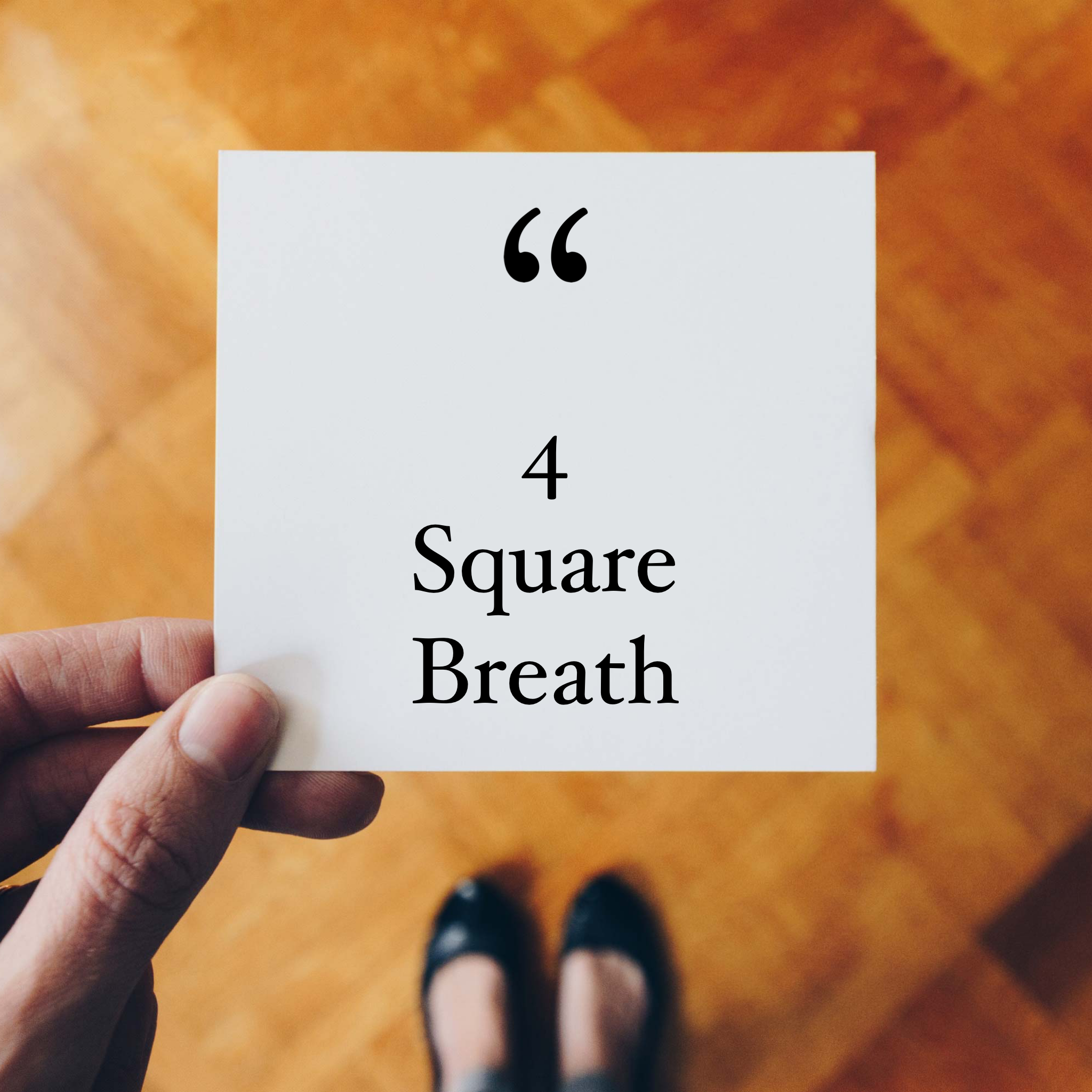 A hand holding a white card with the words 'Quarter Breath' printed on it, with the background of a wooden floor and a person's legs in black shoes.