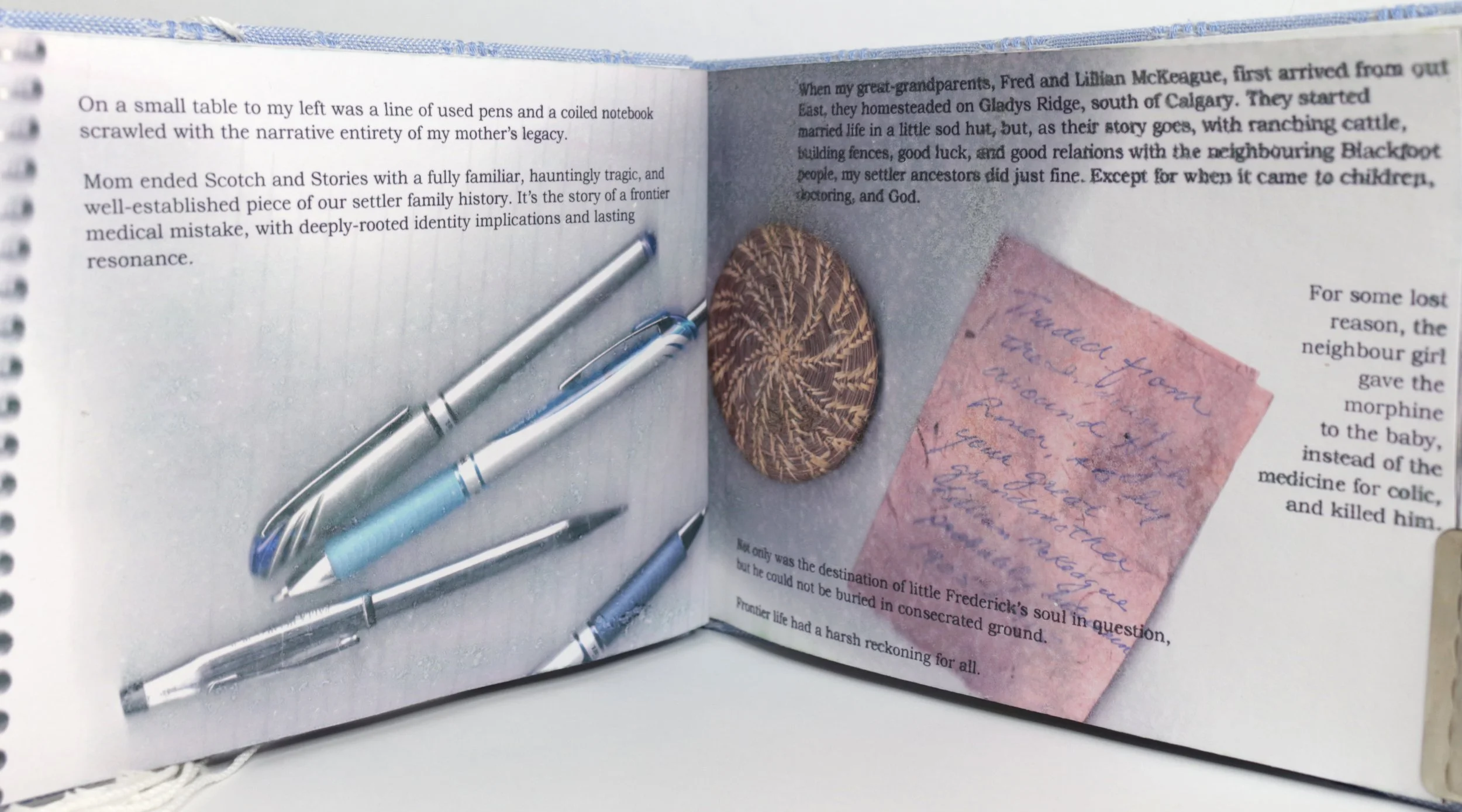 Open book with handwritten pink note, several pens, a brown oval-shaped button or pin, and printed text visible.
