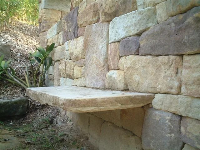 Stone seat nestled into a randomly placed stone wall