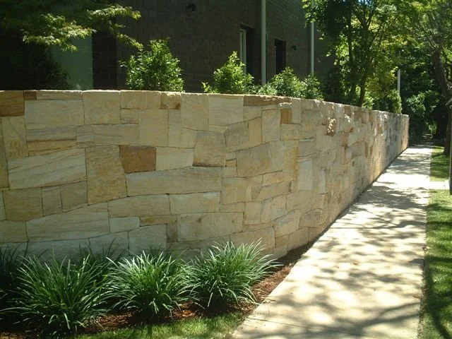 Stone boundary wall sweeping around the corner site