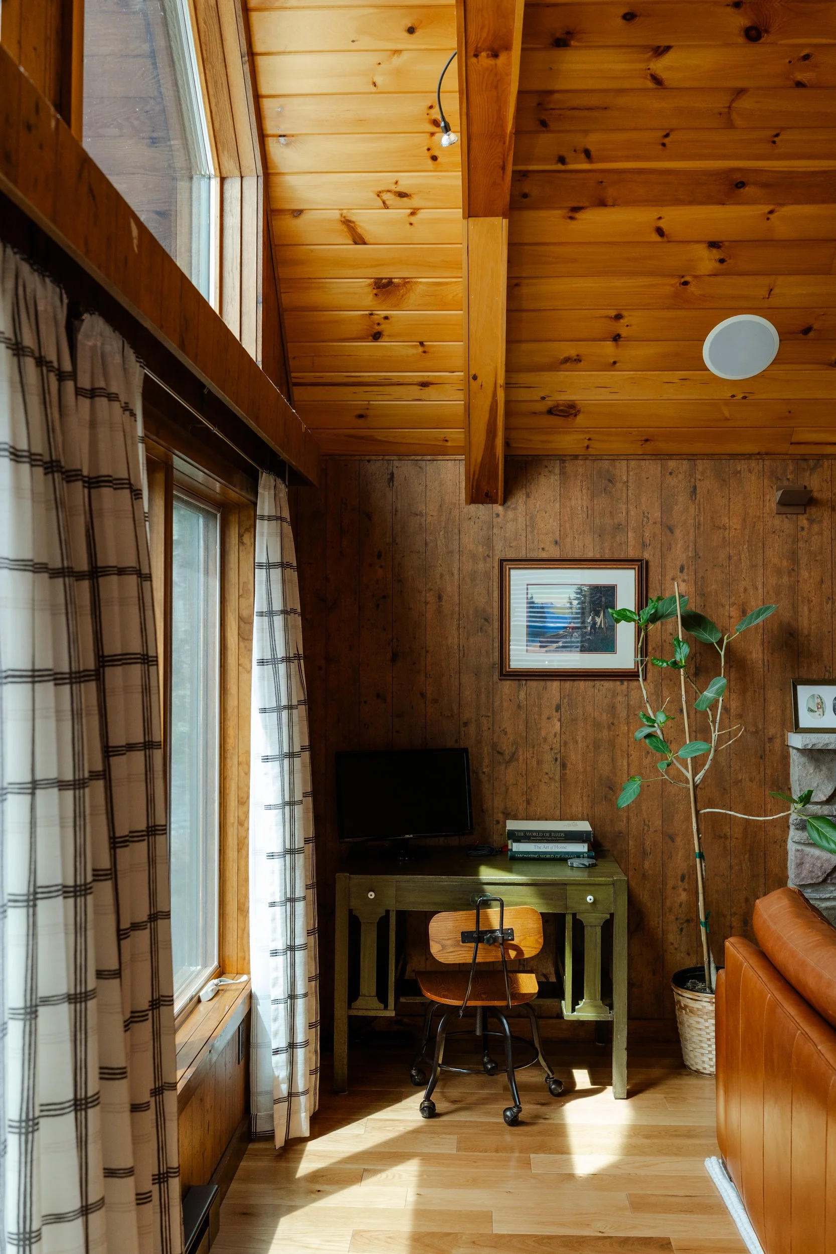 light coming in cabin window by desk wood paneled