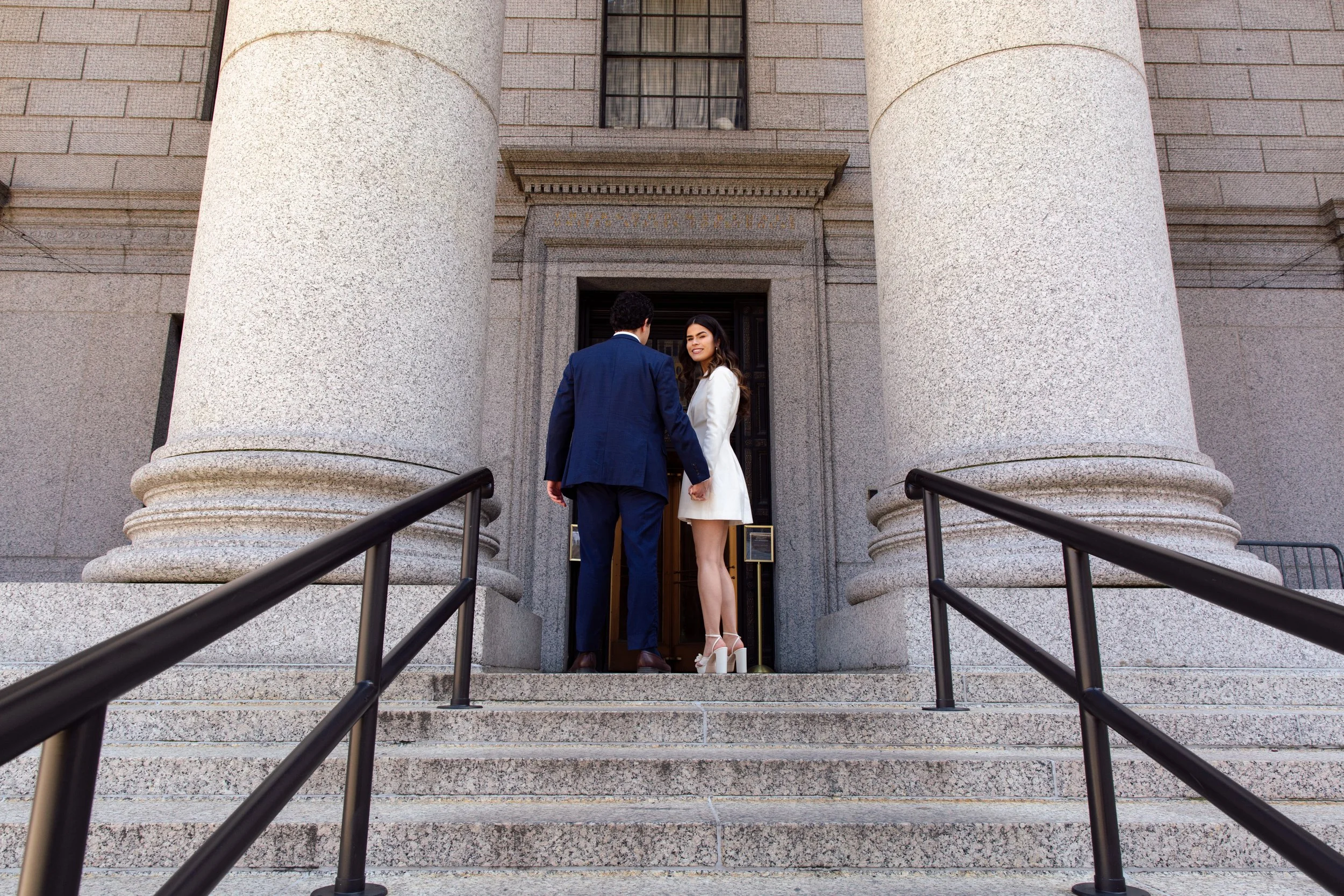 couple entering courthouse building in nyc for wedding ceremony