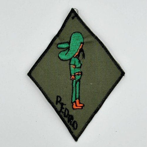 An embroidered patch with a cartoon character standing in profile, wearing a green cap and outfit, with orange shoes, and the name "Pedro" written below.