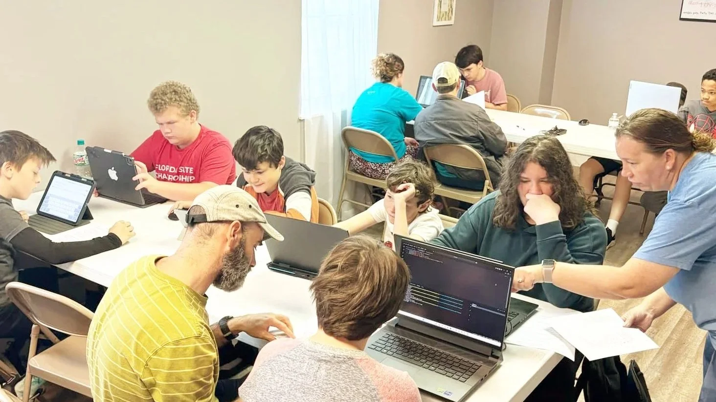 A group of students participating in a hands-on Tech Explorers STEM workshop at Knotty Laser in Panama City, Florida, focusing on 3D design, coding and robotics.