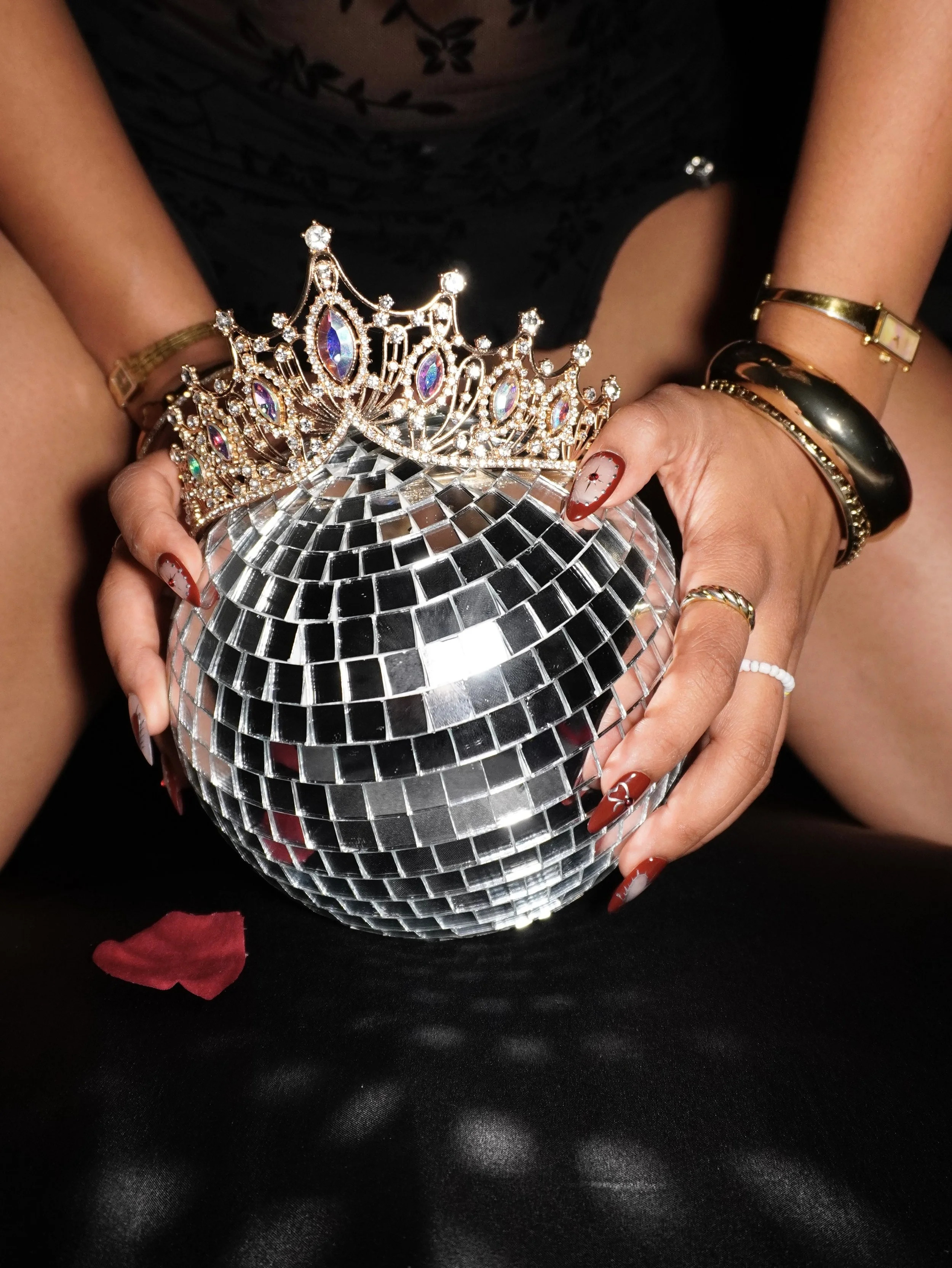 Birthday Picture. Creative directed celebration images. A person holding a disco ball with a large, ornate rhinestone crown resting on top of it.