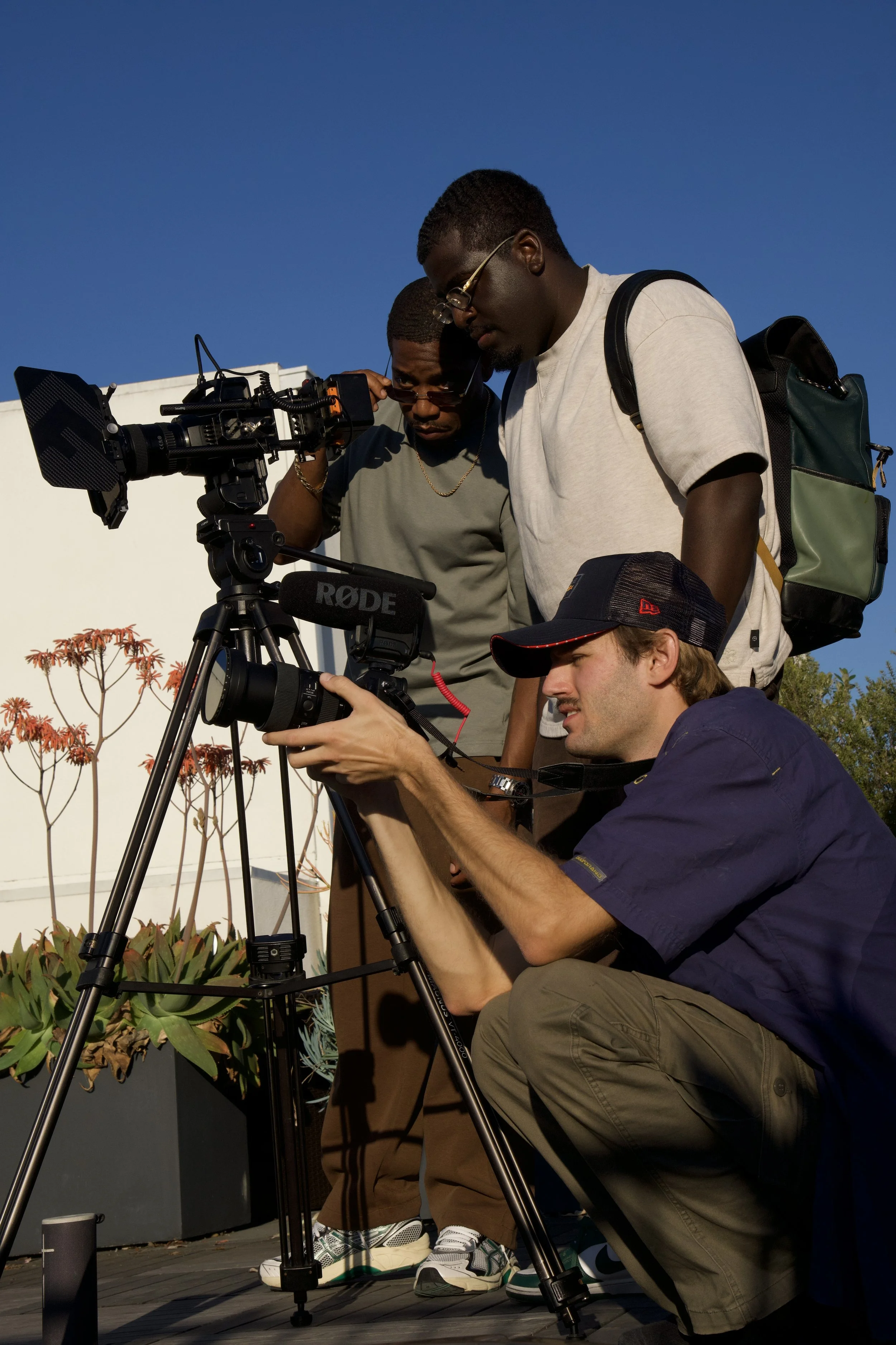 Picture of a director, assistant, and BTS photographer around cameras.