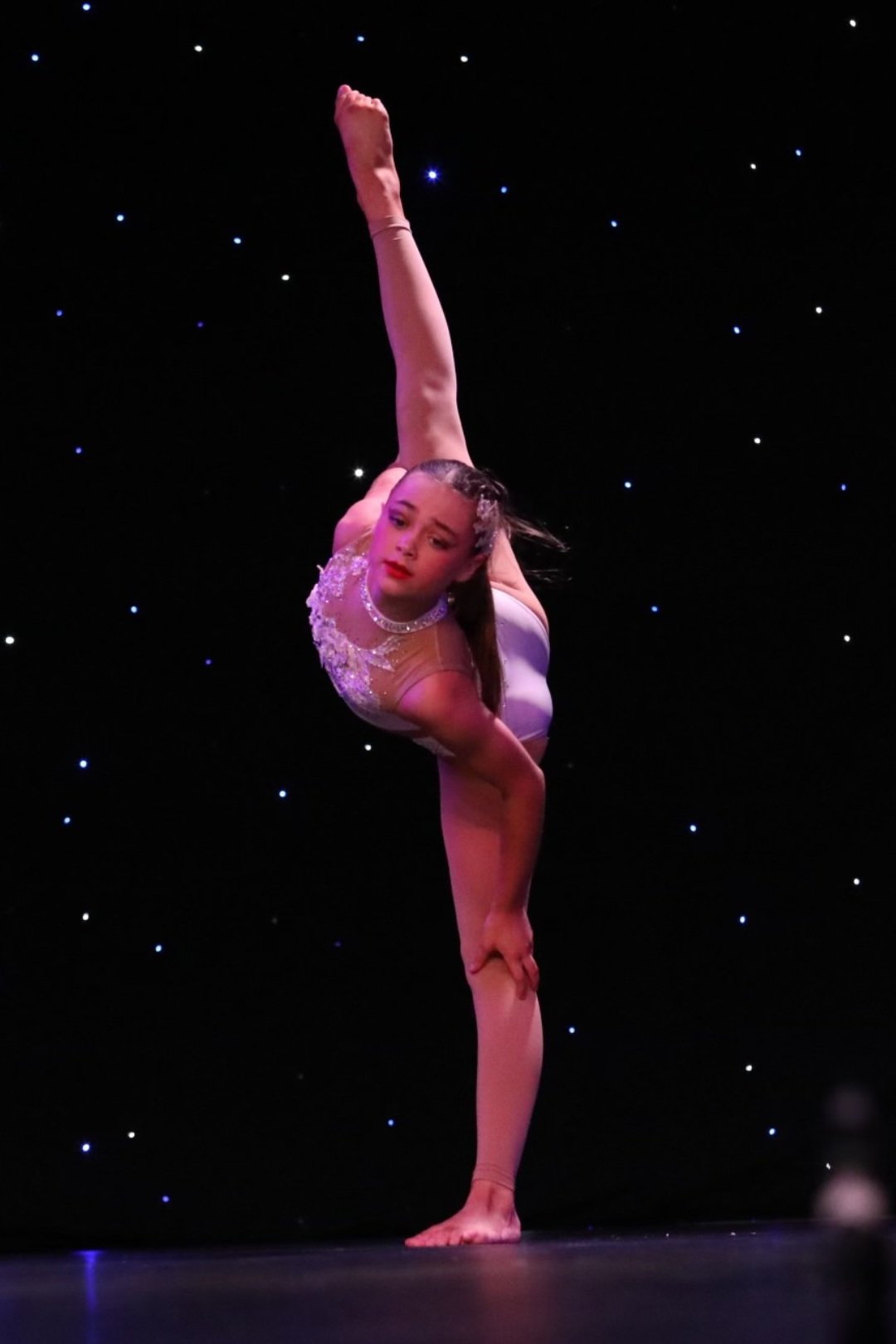 Dancer on stage doing leg mount