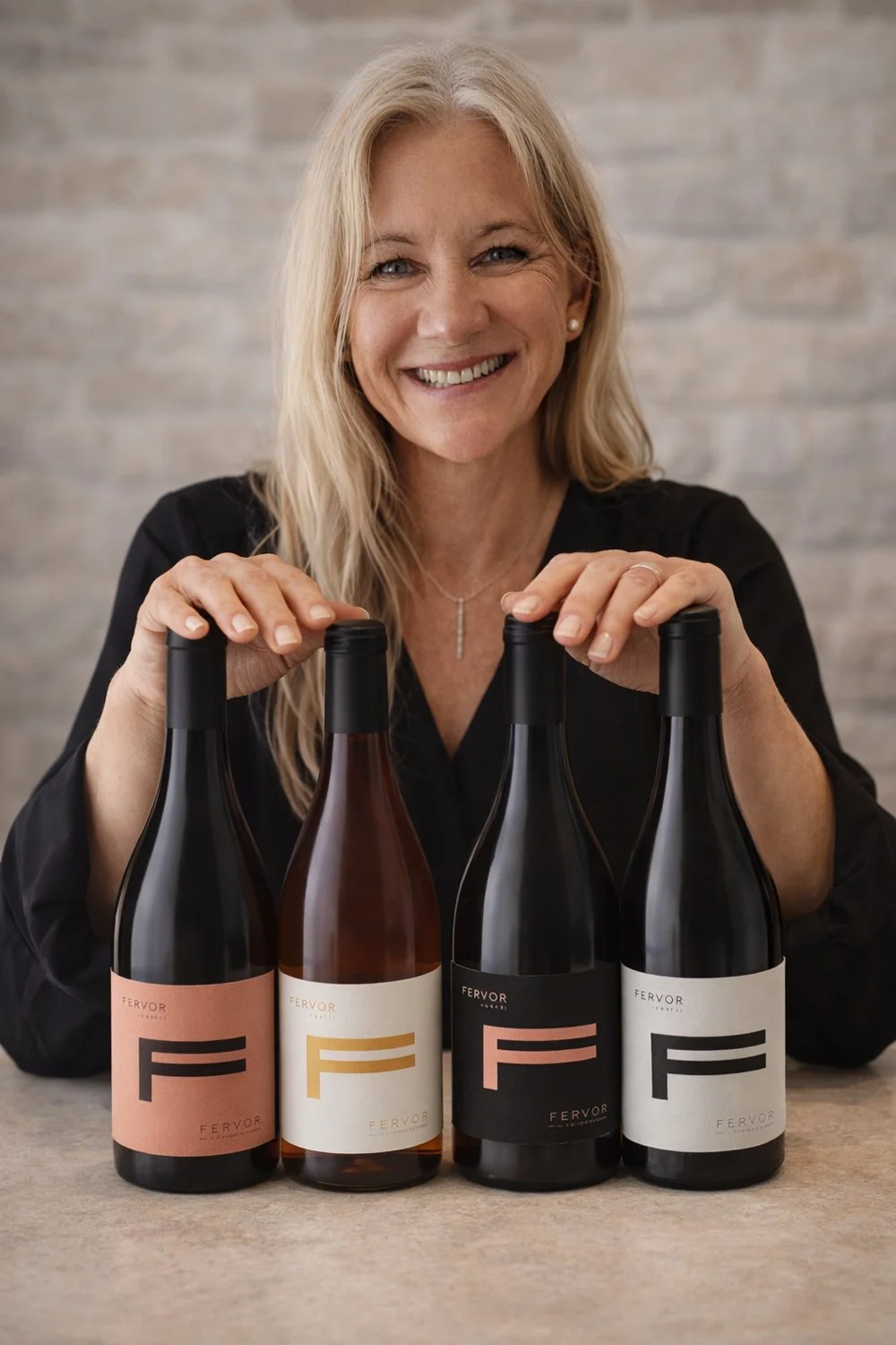 Tracey Whooley smiling behind four bottles from the Fervor Wines range.
