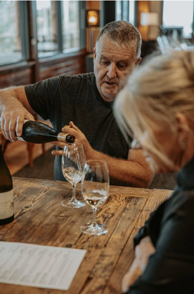 Cellar door host pouring wine for a guest during a tasting in Frankland River.