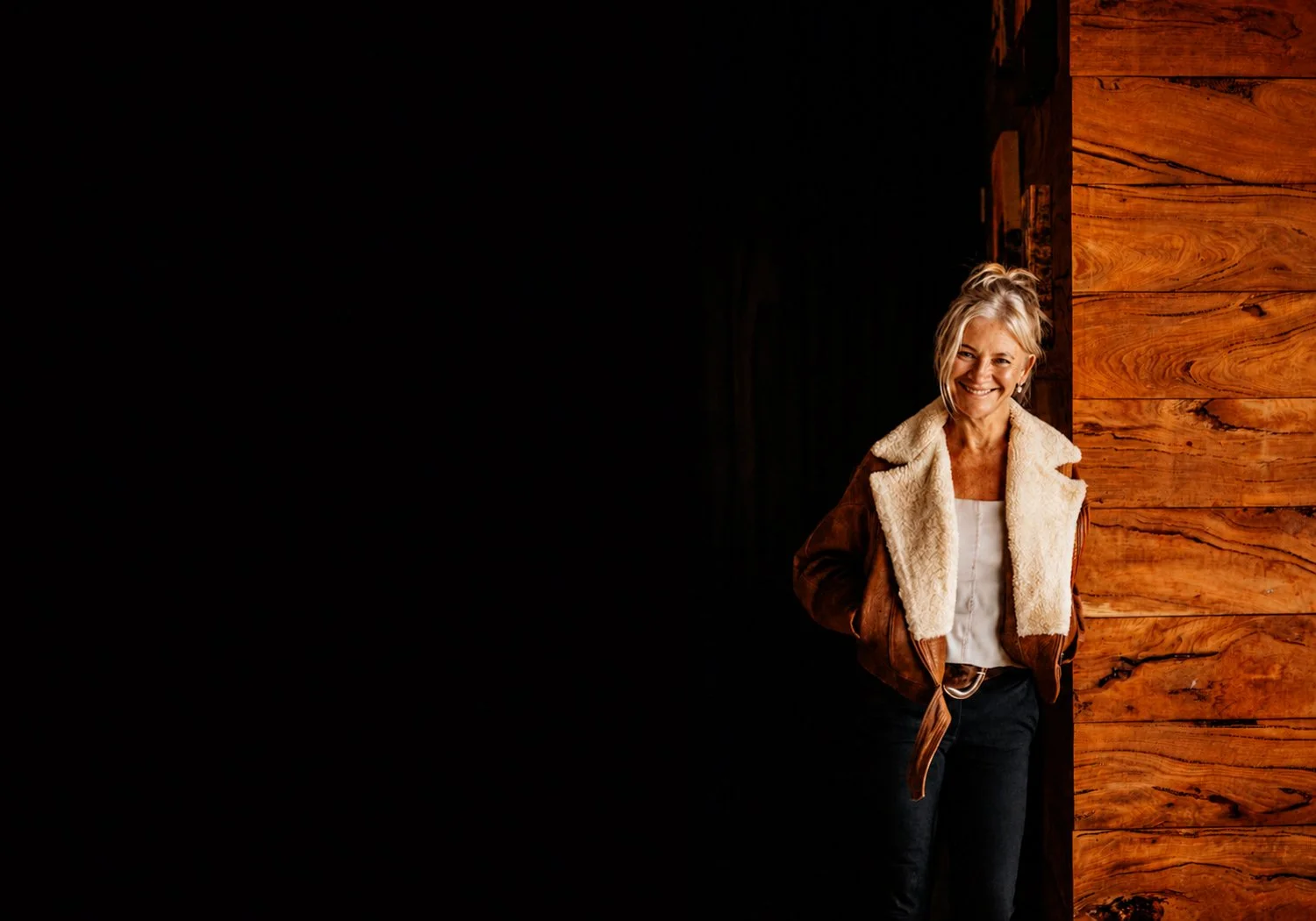 Tracey Wholley smiling in a warmly lit timber doorway at a Great Southern wine venue.