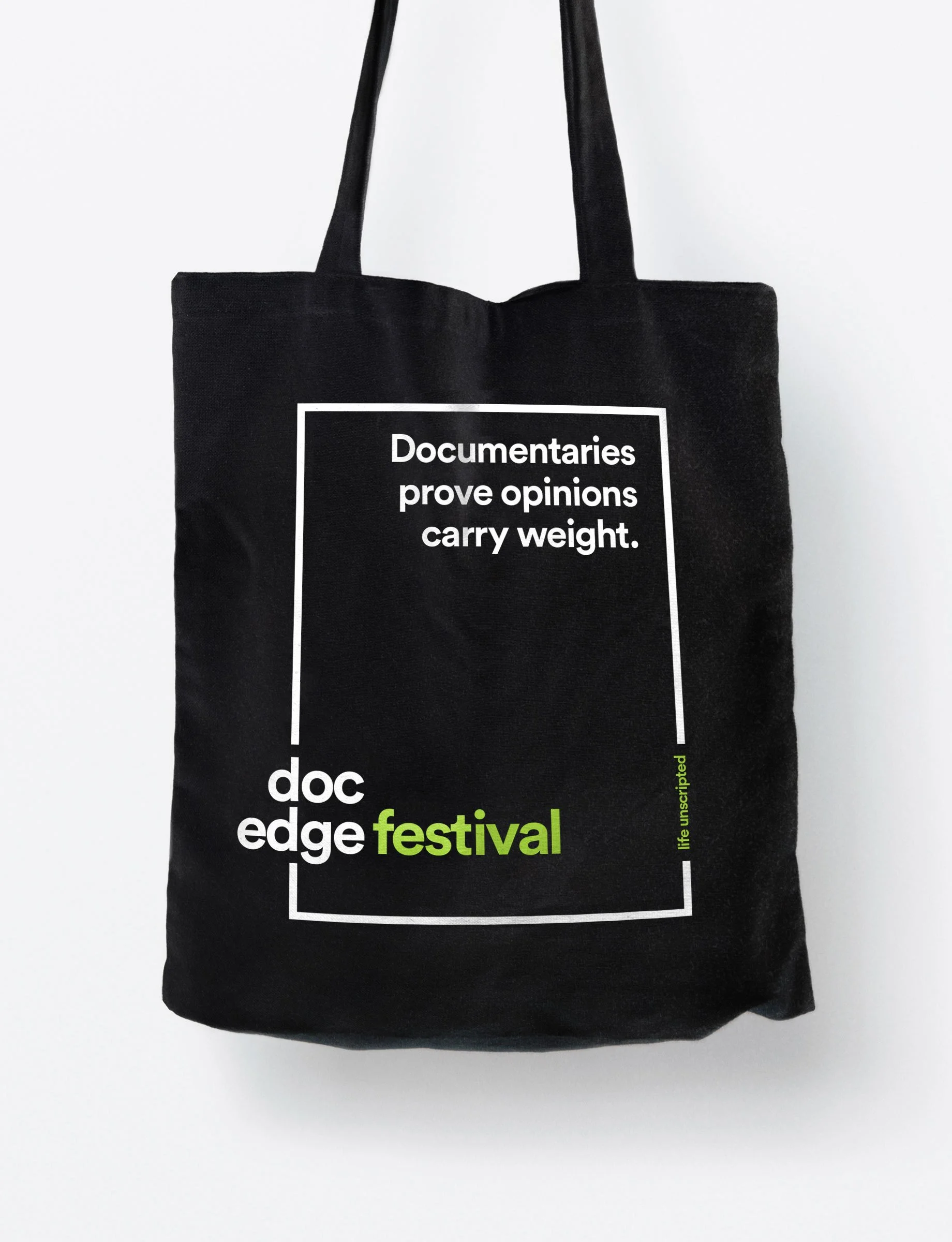 Black tote bag with white and green text about documentary film festival.