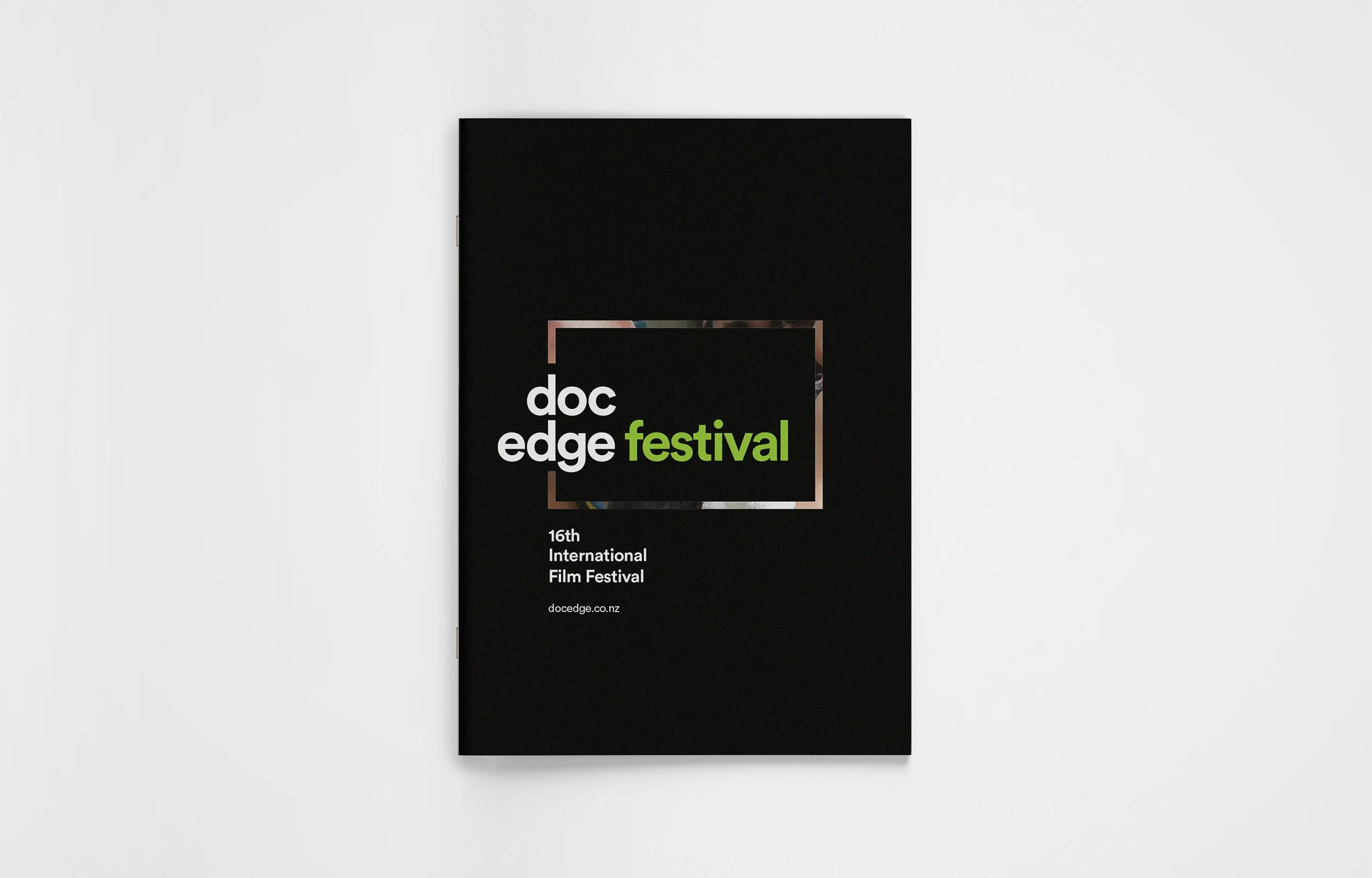Black program flyer for the 16th International Film Festival called 'Doc Edge Festival' with white and green text and a minimalistic design.