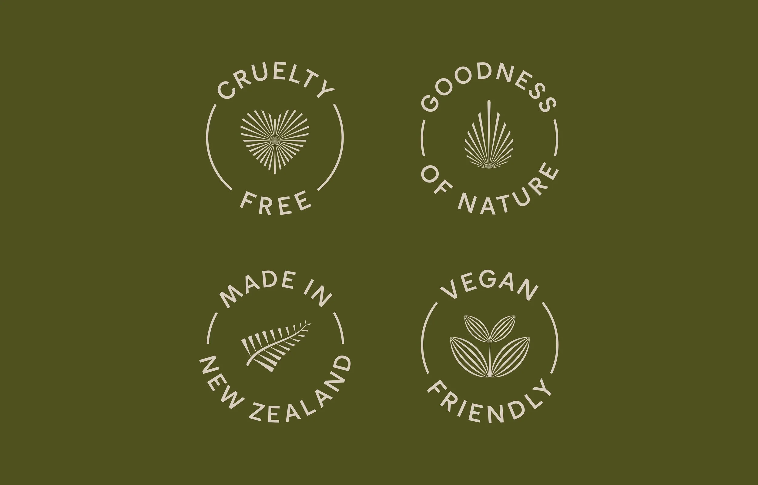 Four circular logos on a green background, each with text and a line drawing. The top left logo says "Cruelty Free" with a heart made of radiating lines. The top right says "Goodness of Nature" with a leaf icon. The bottom left says "Made in New Zealand" with a stylized fern leaf. The bottom right says "Vegan Friendly" with a plant with three leaves.