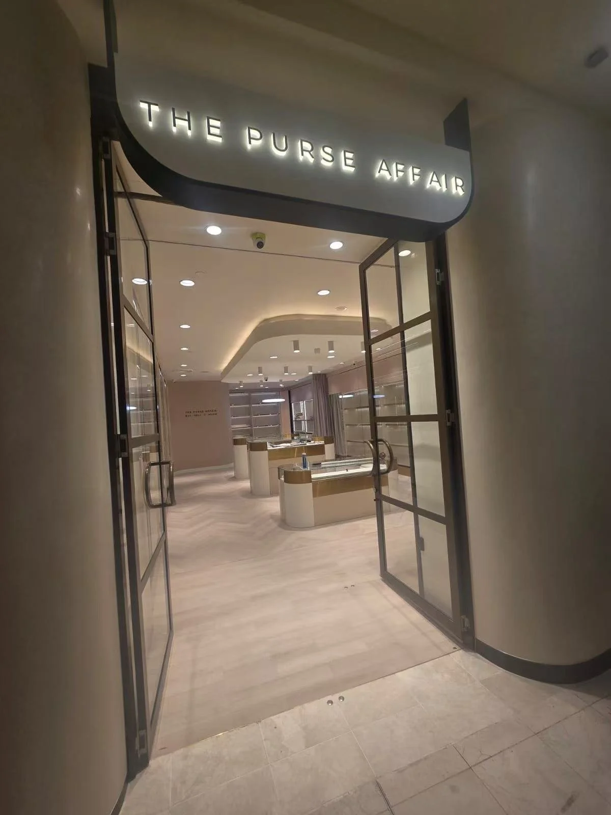 Entrance to a jewelry store named 'The Purse Affair' with glass display cases inside.