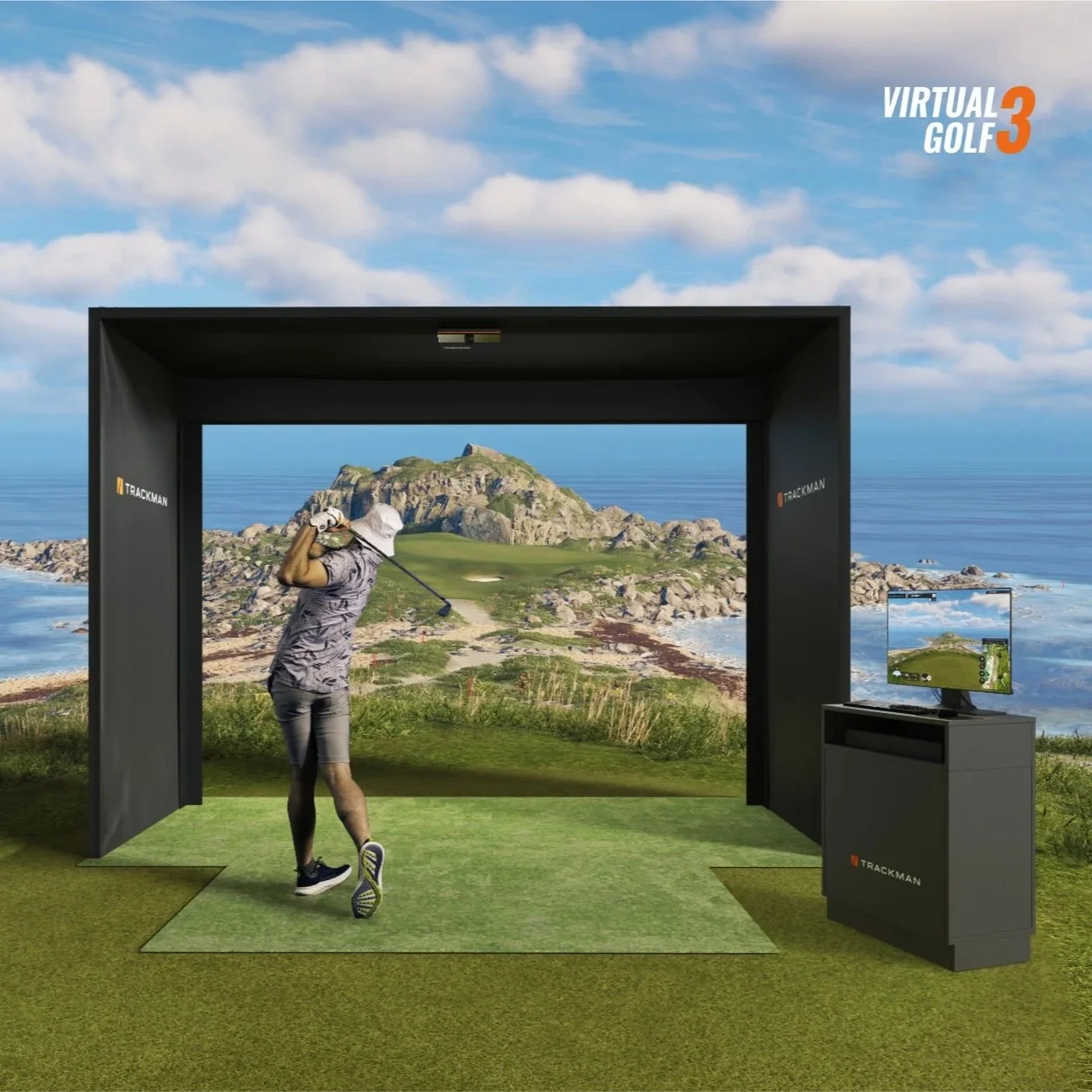 A person playing virtual golf inside a simulation at a golf course backdrop with ocean and mountains, using a golf club and standing on a green mat, with a monitor on a stand displaying the virtual game environment.
