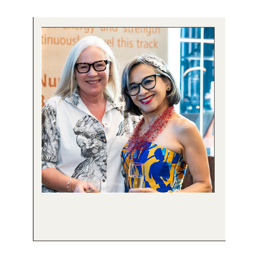 Heather Wallace and Lan Tran co-founders of Be Savvy smiling with glasses and drinks at a celebration or event.