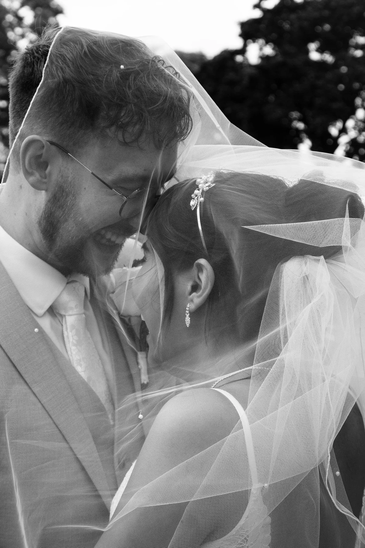 Vanessa and Ethan giggling underneath her veil.
