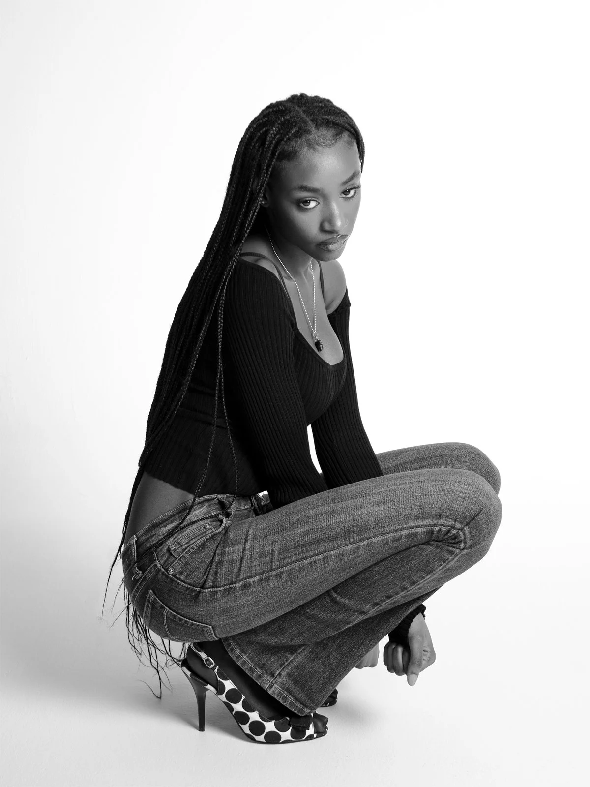 Black and white crouching portrait of Sommer shot in a Toronto studio.