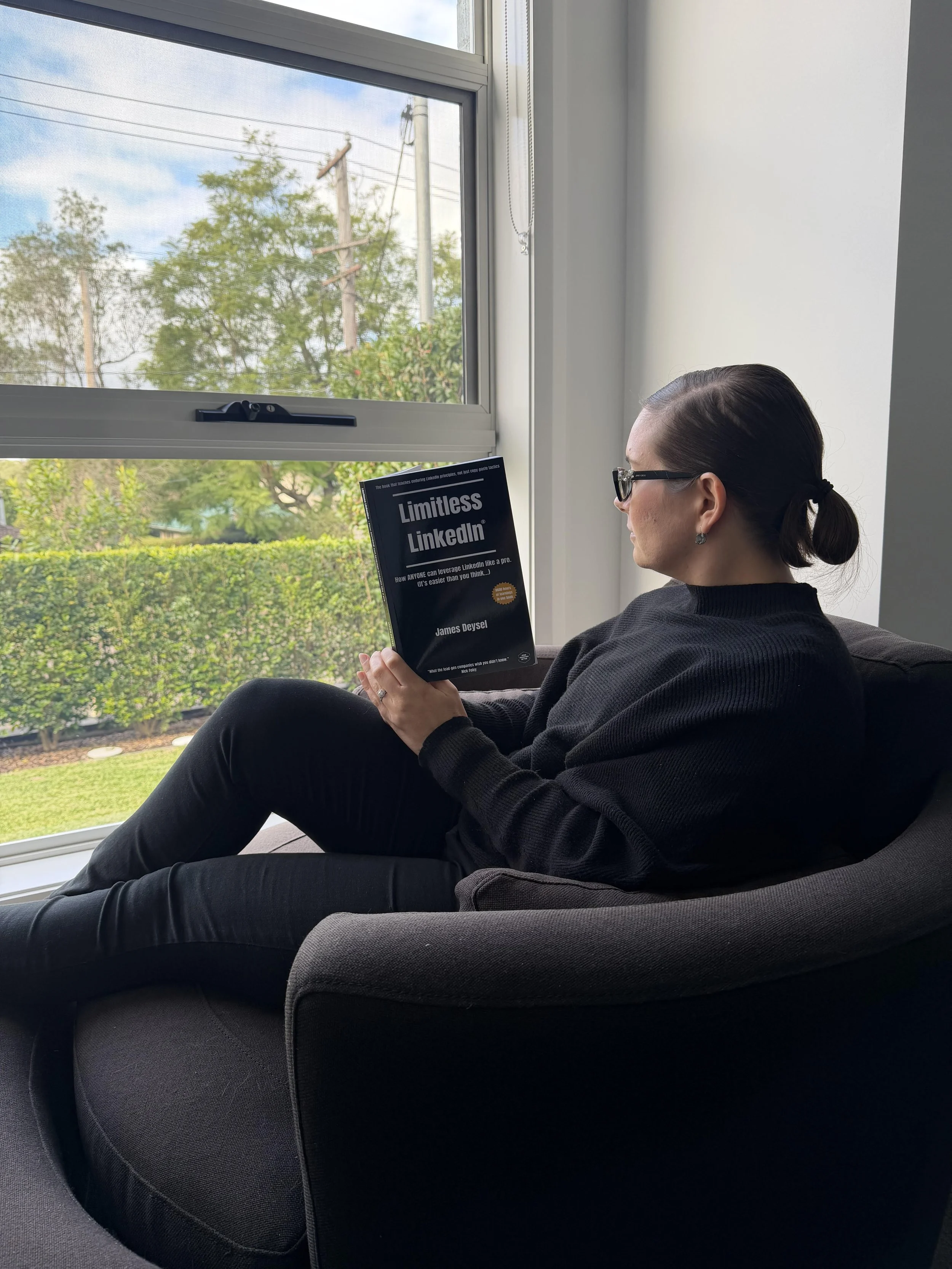 Limitless LinkedIn Reader reading the book on a couch