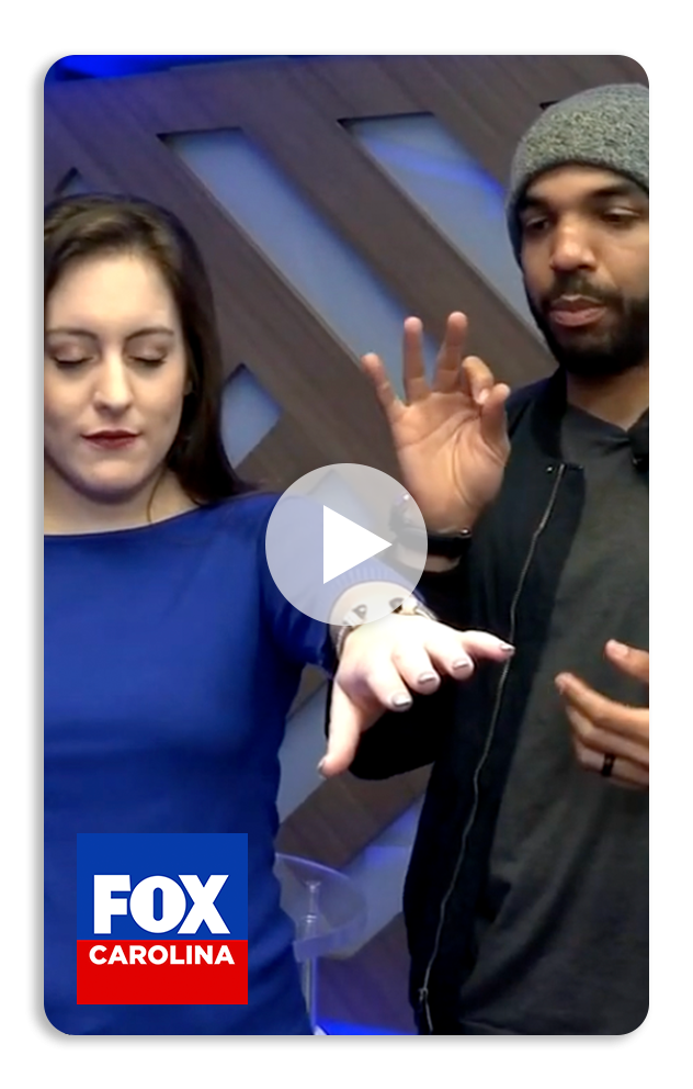 Chrisjones hypnotizing a woman and  on camera, with a Fox Carolina logo in the bottom left corner.