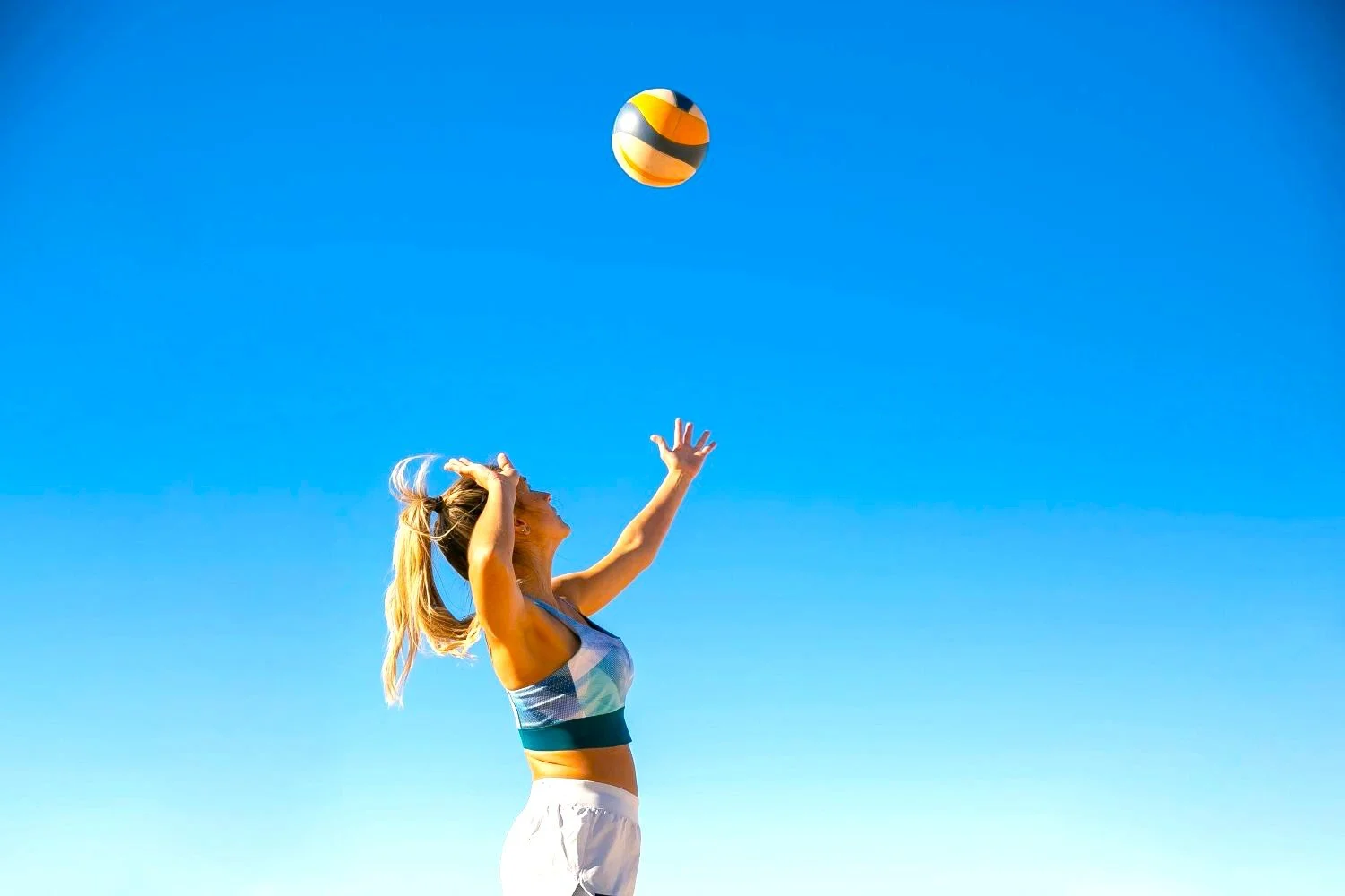 A woman serving a volleyball