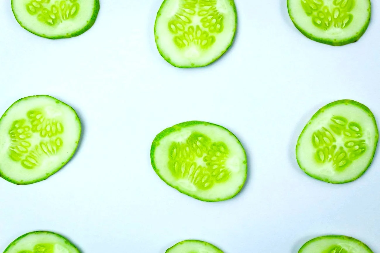 Sliced cucumbers on a light blue background