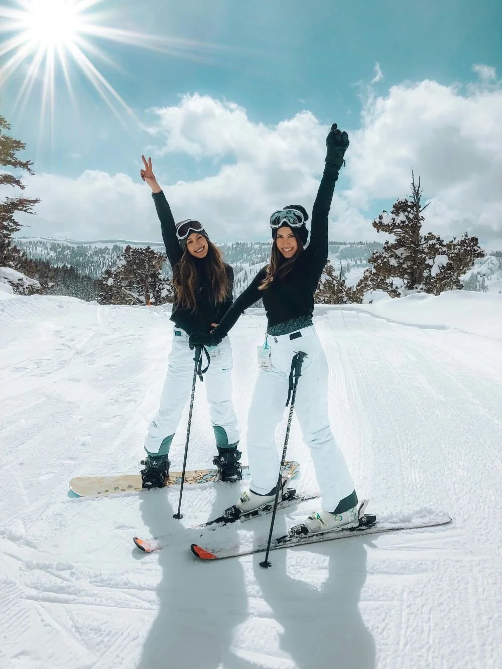 Two woman skiing, smiling and waiving