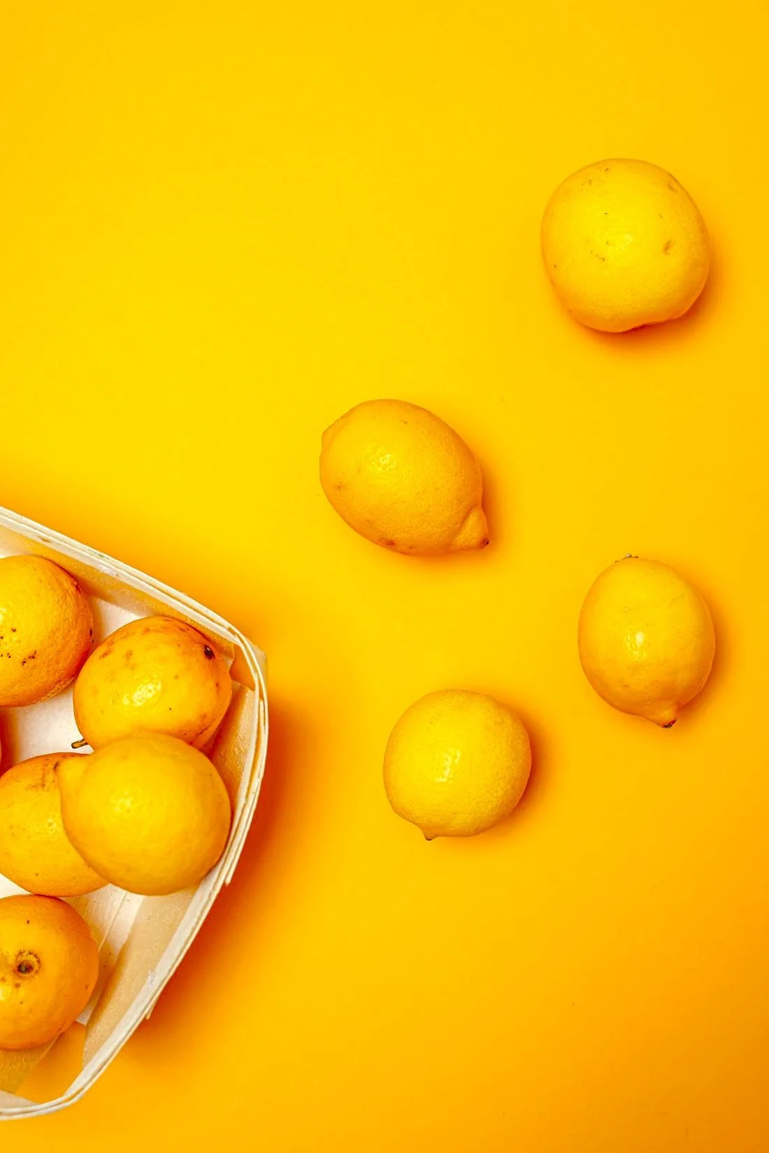 Lemons sitting on a yellow background