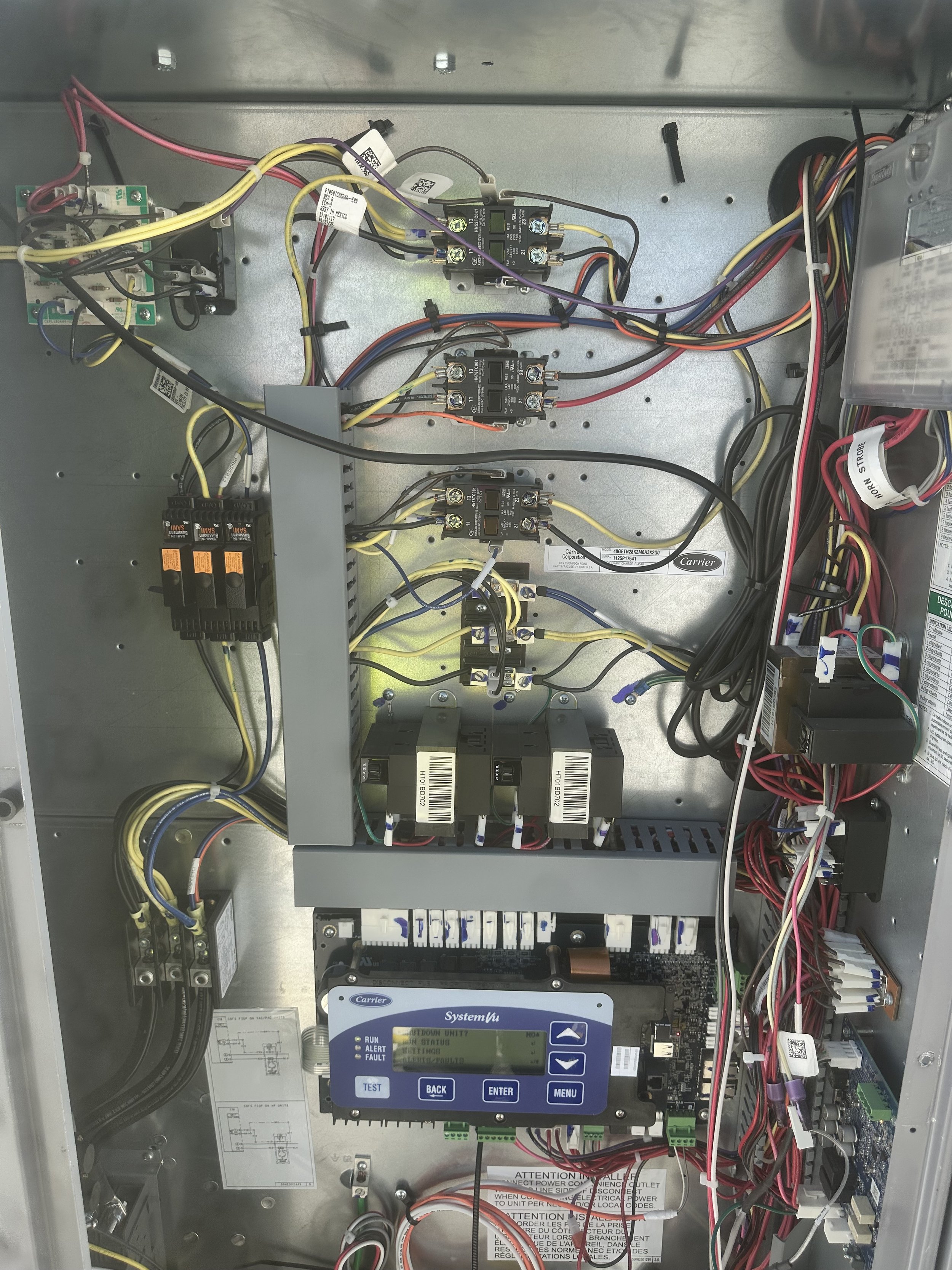Interior view of an electrical control panel with various wires, relays, and circuit components.