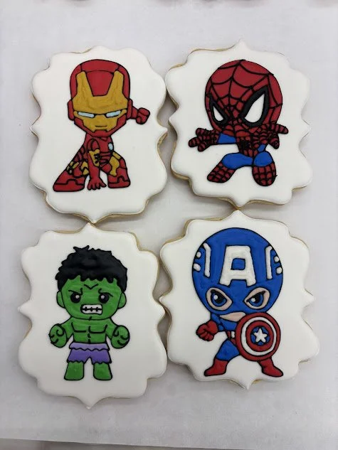 Cookies decorated with Marvel superhero characters Iron Man, Spider-Man, Hulk, and Captain America.