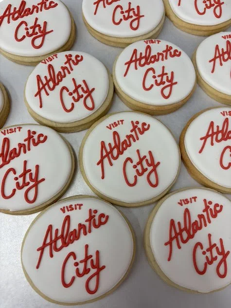 Cookies with white icing and red writing that says "Visit Atlantic City".