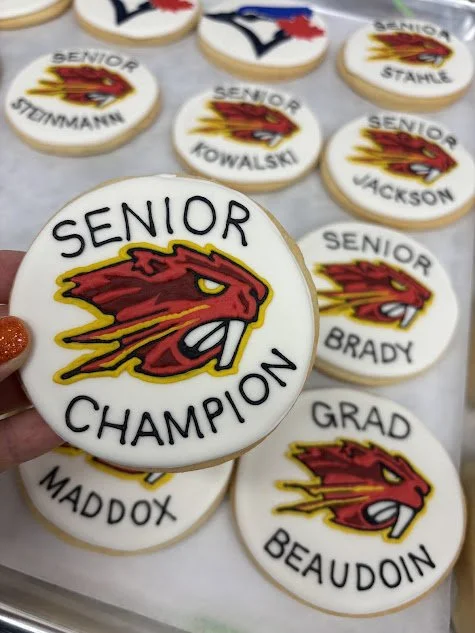Decorated cookies with a red and yellow fierce dragon logo and text like "Senior Champion," "Grad," and names of seniors.