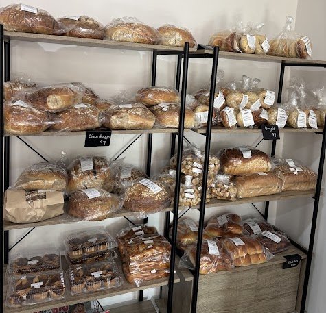 Shelves filled with various packaged bread and baked goods in a bakery store.