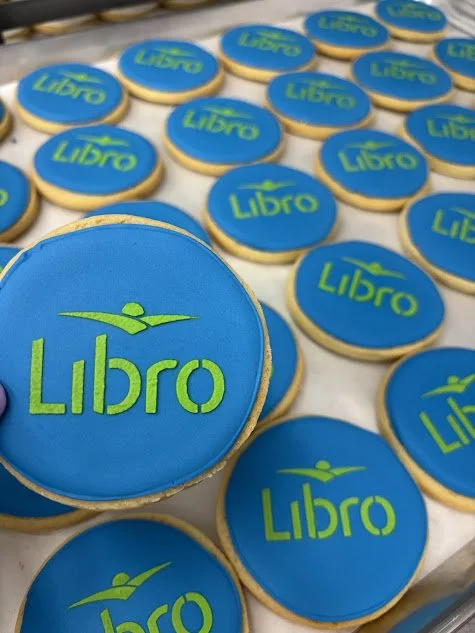 Cookies decorated with blue icing and green logo reading "Libro" with a stylized person above the text.