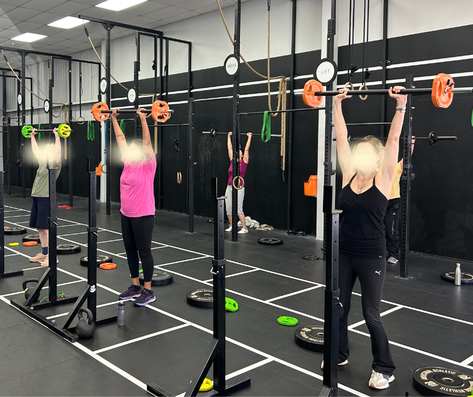 Multiple people lifting barbells with weights at a gym focusing on strength training