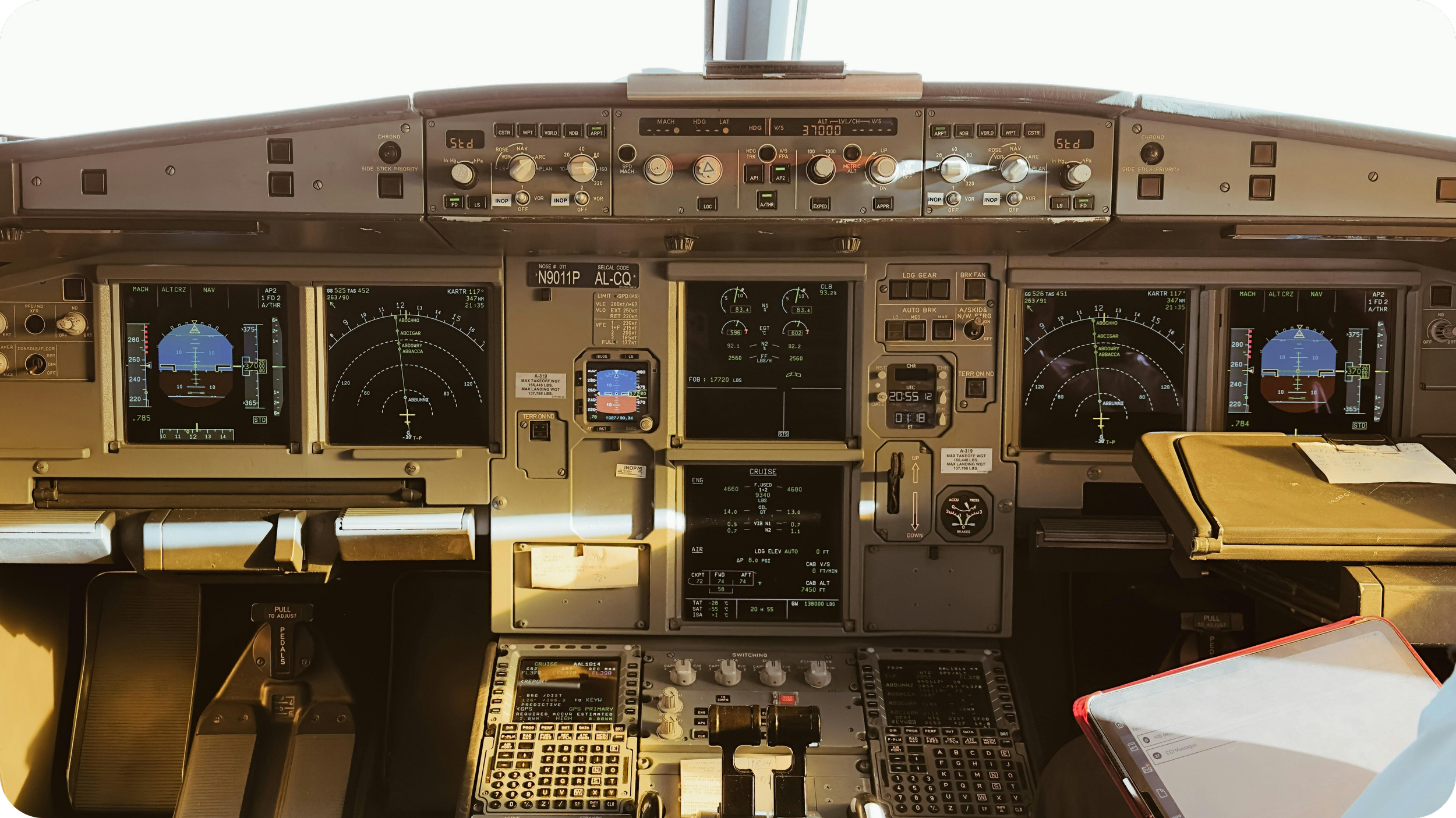 View of an airplane cockpit dashboard with multiple digital and analog instruments, screens, and controls.