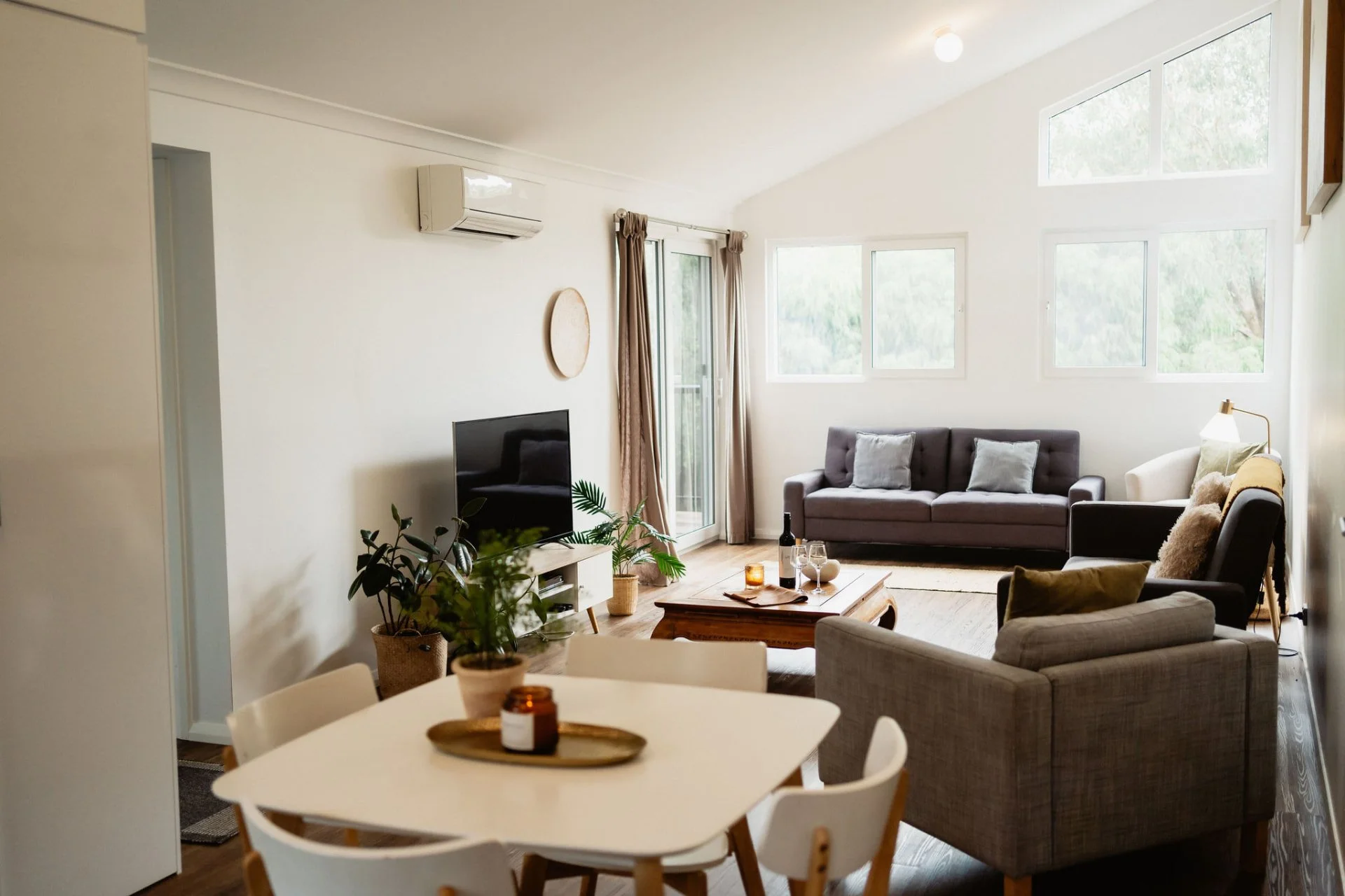 Bright open plan living and dining area with sofas and a dining table