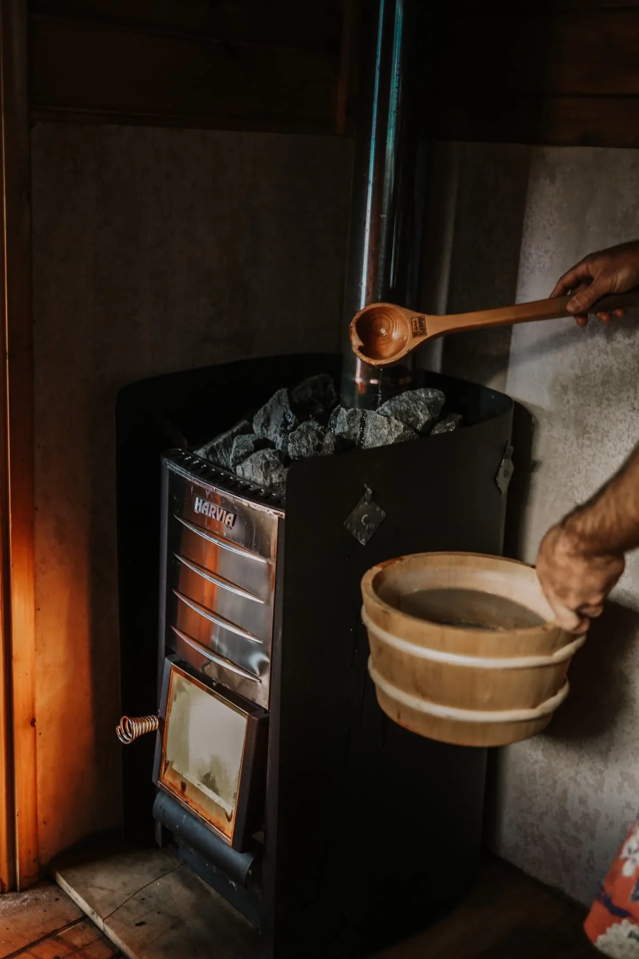 Water being ladled over hot stones in a sauna